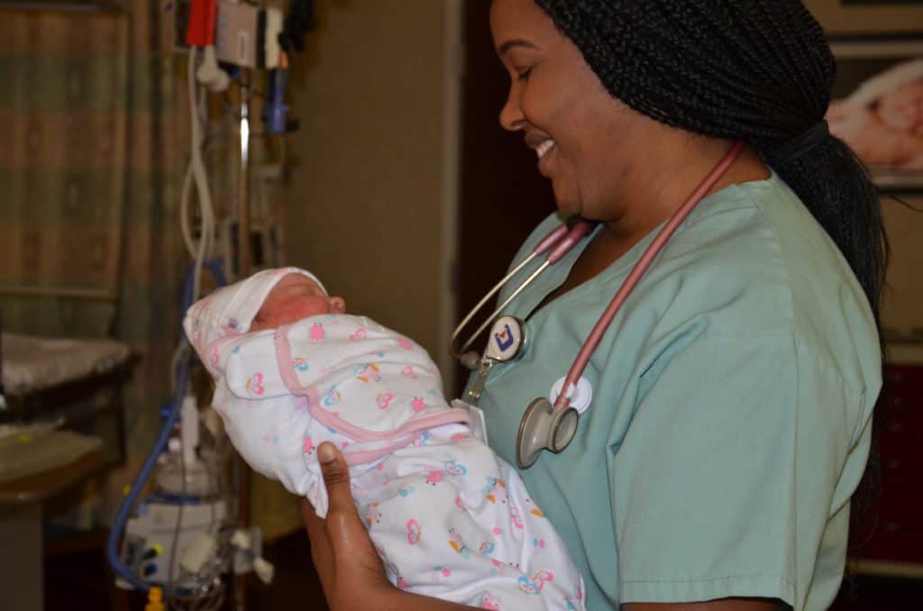 a nurse holding a newborn infant